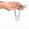 Pinzas Kink con triple cadena plateada sostenidas con la mano, cadenas colgando