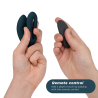 We-Vibe Sync O azul petróleo plegado en una mano y el mando remoto en la otra