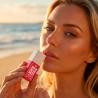 Mujer en la playa con el gel INTT Suck My Clit de fresa