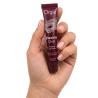 Mano sosteniendo el tubo de gloss labial Orgie Electric Oral